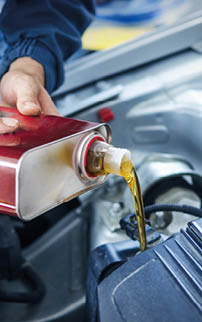 Mechanic changing engine oil on car vehicle.